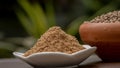 Coriander seeds in a clay bawl, and powder.