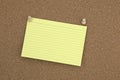 Cork board with tacks, yellow flash card at jaunty angle Royalty Free Stock Photo