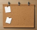 Cork board with white sticky notes or sheets of note paper.