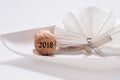 Cork with the number 2018 on the plate with white napkin