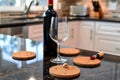 cork coasters with wine bottle and glass on a kitchen counter