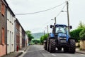 CORK, IRELAND - JUNE, 6 2012: A blue New Holland tractor on road in rural area, Dingle, Ireland