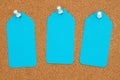 Corkboard with 3 blue gift tags and pushpin