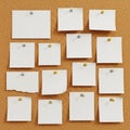 A corkboard displaying 15 blank white square notes pinned with thumbtacks in various Royalty Free Stock Photo