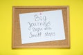 Corkboard with pinned message Big Journeys Begin With Small Steps on yellow background, top view. Motivational quote Royalty Free Stock Photo