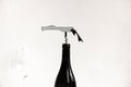 Corkscrew in a black bottle of wine with a glass of wine on the side against a white background Royalty Free Stock Photo