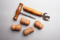 Corkscrew, bottle opener and wine corks on a gray background