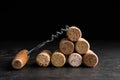 Corkscrew and stack of wine bottle stoppers on slate table, closeup Royalty Free Stock Photo