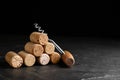 Corkscrew and stack of wine bottle stoppers on slate table. Space for text Royalty Free Stock Photo