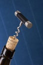 Corkscrew and wine bottle over blue background Royalty Free Stock Photo