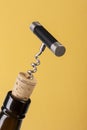 Corkscrew and wine bottle over yellow background Royalty Free Stock Photo