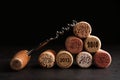 Corkscrew and wine corks with different dates on slate table, closeup Royalty Free Stock Photo