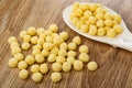 Corn balls in white spoon, scattered corn balls on wooden table Royalty Free Stock Photo