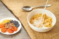 Corn bowl with fresh pouring milk and dried fruits on the plate