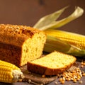 Corn bread loaf with a slice cut, corn cobs and kernels on a dark background corn kernels Royalty Free Stock Photo