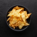 Corn chips or nachos chips in black bowl on black rustic background Royalty Free Stock Photo