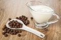 Corn chocolate balls in spoon on heap of balls, sauce boat with yogurt on table