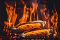 Corn on the cobs cooking on a fiery BBQ grill cob