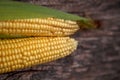 Corn cobs lie on a wooden table. Ripe corn lies on a textured old table. Royalty Free Stock Photo