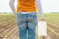 Corn crop protection concept, female farmer agronomist holding jerry can container canister with pesticide