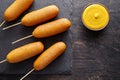 Corn dog traditional American corndog street junk food deep fried hot meat sausage snack with yellow mustard