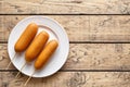 Corn dog traditional American street food deep fried hot sausage snack on white plate
