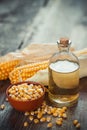 Corn essential oil bottle, seeds in bowl and two corncobs Royalty Free Stock Photo