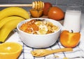 Corn Flakes Bowl with Banana, Milk, Persimmon, Orange and Honey on white background, Healthy Breakfast Royalty Free Stock Photo