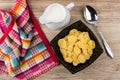 Corn flakes in bowl, jug of milk, spoon and napkin Royalty Free Stock Photo