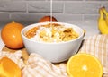 Corn Flakes Bowl with Milk, Persimmon, Orange and Wooden Spoon on white background, Healthy Breakfast Royalty Free Stock Photo