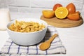 Corn Flakes Bowl with Milk, Persimmon, Orange and Wooden Spoon on white background, Healthy Breakfast Royalty Free Stock Photo