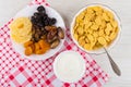 Corn flakes in bowl, sour cream, dried fruits in plate Royalty Free Stock Photo