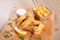 Corn flakes deep fried chicken sticks andfrench fries, served on wooden board Royalty Free Stock Photo