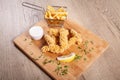 Corn flakes deep fried chicken sticks and french fries, served on wooden board Royalty Free Stock Photo