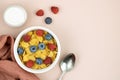 Corn flakes with milk, berries and a spoon on a pink background, top view. copy space. Royalty Free Stock Photo