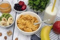 Corn flakes with milk and fresh banana, kiwi and apple, as well as fresh strawberries, blueberries and nuts. Royalty Free Stock Photo