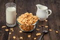 Corn flakes with milk jug and glass on wooden table Royalty Free Stock Photo