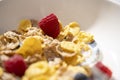 corn flakes with milk and raspberries in white bowl. Selective focus Royalty Free Stock Photo