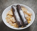 Corn flakes with milk and two chocolate wafer rolls for brealfast