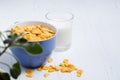 Corn flakes and milk on a white wooden background. Healthy breakfast. Copy space