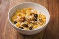 Corn flakes with nuts and fruits in white bowl on wood table Royalty Free Stock Photo