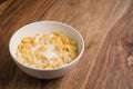 Corn flakes poured with milk in white bowl on table Royalty Free Stock Photo