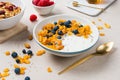 Corn flakes with yogurt, almonds, blueberries, raspberries and c