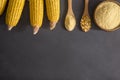 Corn flour in wooden bowl and spoon with dried corn groats, kernels on rustic table Royalty Free Stock Photo