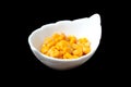 Corn grains in a decorative ceramic bowl, close-up, black background Royalty Free Stock Photo