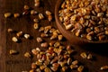 Corn grains in a wooden bowl and in bulk on a wooden table Royalty Free Stock Photo