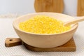 Corn grits in a wooden bowl. The concept of the production of cereals from grain, products from corn