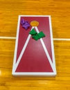 Corn hole game with colorful bean bags inside on a gym floor