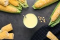 Corn juice and cobs on black slate background, flat lay Royalty Free Stock Photo
