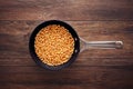 Corn maize or kernel seed in a frying pan on a wooden kitchen table